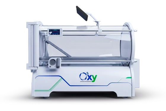 Câmara hiperbárica monoplace Oxy da linha atual vista de frente, com o vaso de acrílico, o painel digital no trilho e o monitor recolhido sobre o braço articulado