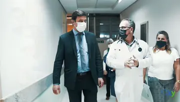 Equipe caminhando pelo corredor de um hospital universitário