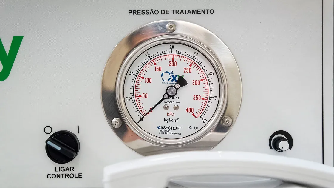 Close do manômetro de pressão de tratamento da Ecobar, com escala em kPa e kgf/cm², ao lado da chave Ligar Controle