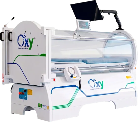Câmara hiperbárica monoplace Oxy 1000, de lado, com cúpula de acrílico, leito, monitor no braço articulado e faixas azul e verde na base